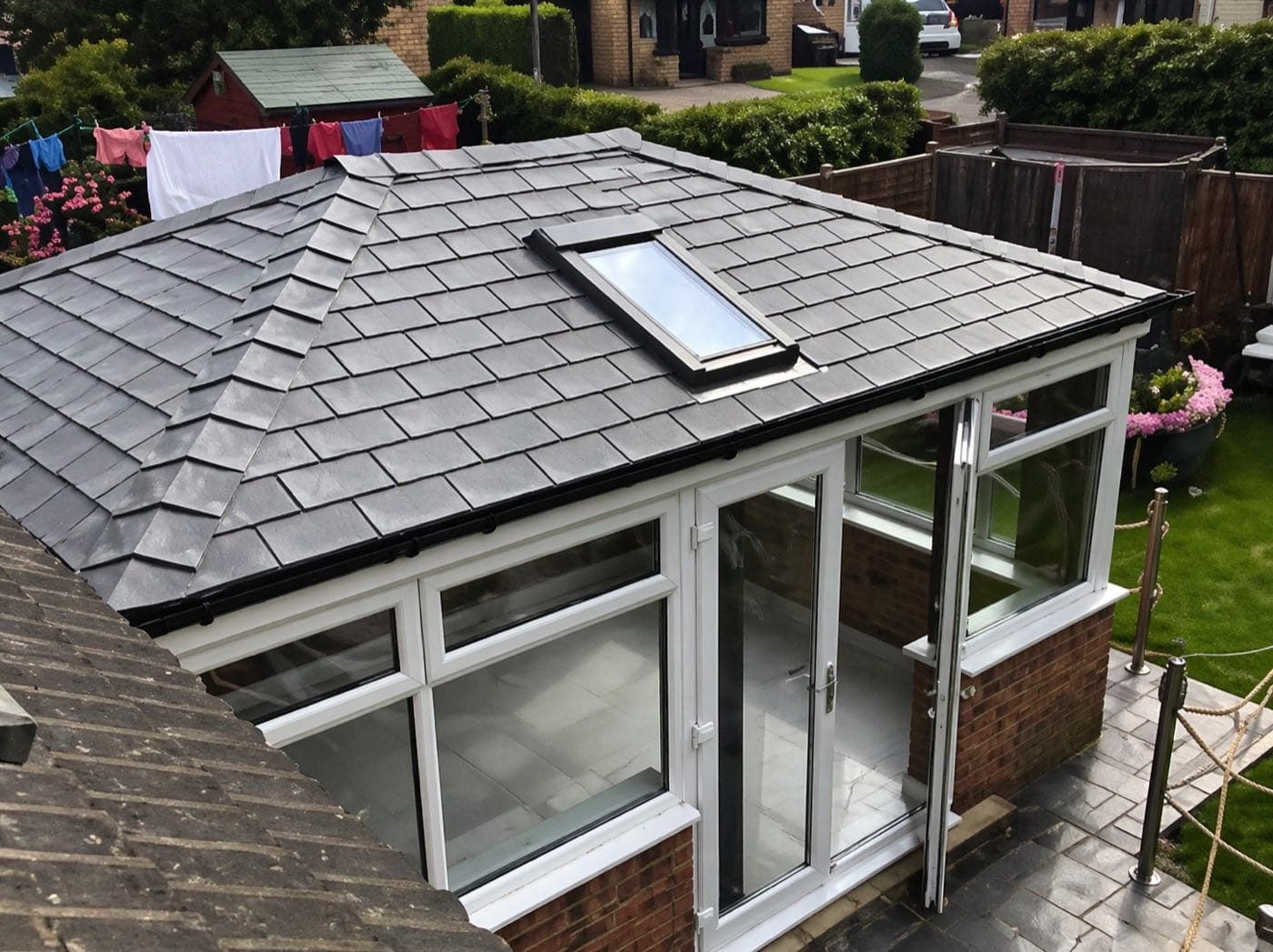 An elevated view across a completed grey tiled warm roof with a skylight built into it