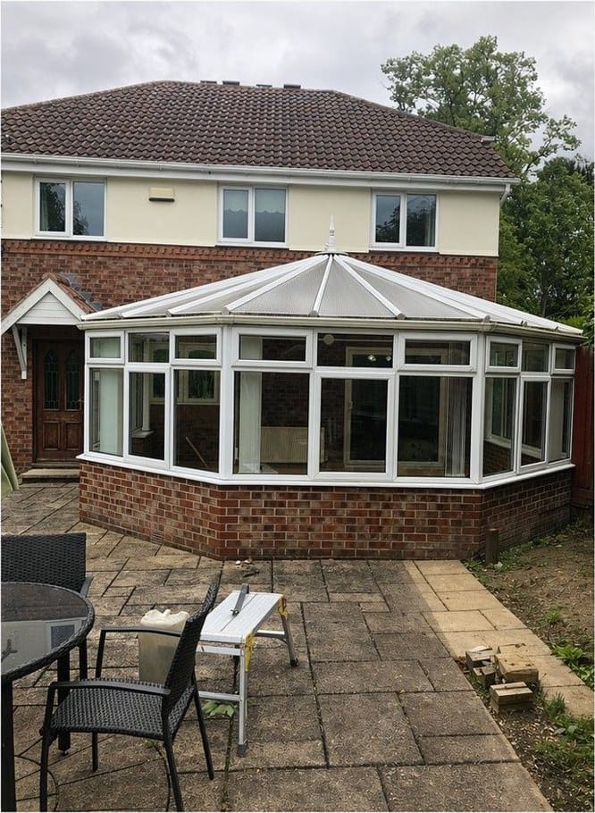 A conservatory with its original glass roof, before the work
